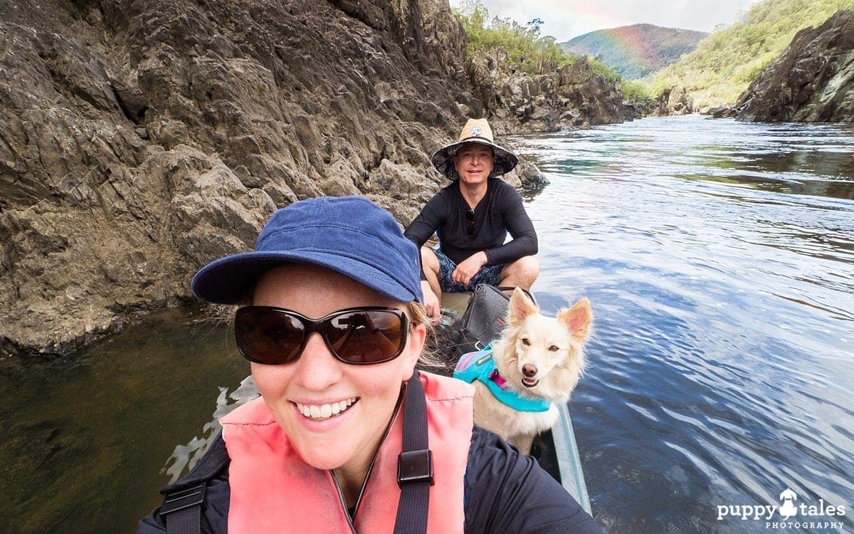 a man and a woman canoeing with their dog