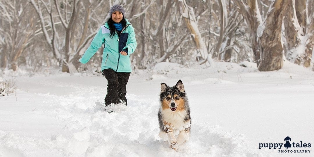 a woman enjoying the snow with her dog