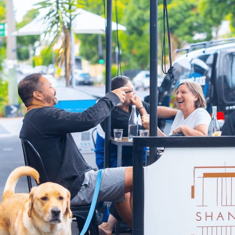 A group of people having a good time outside a dog friendly cafe in Melbourne