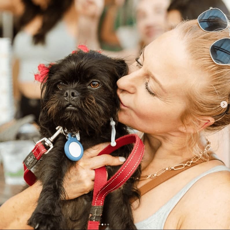 Owner kissing her dog in the cheek as they dine in this pet friendly cafe in Melbourne