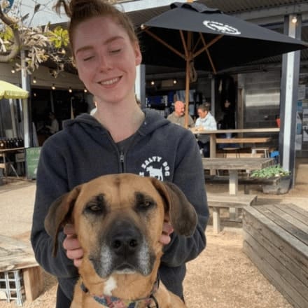 Owner and dog posing for the camera as they dine in this pet friendly cafe